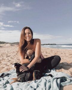 A woman on the beach with her dog during a beach holiday with her pets