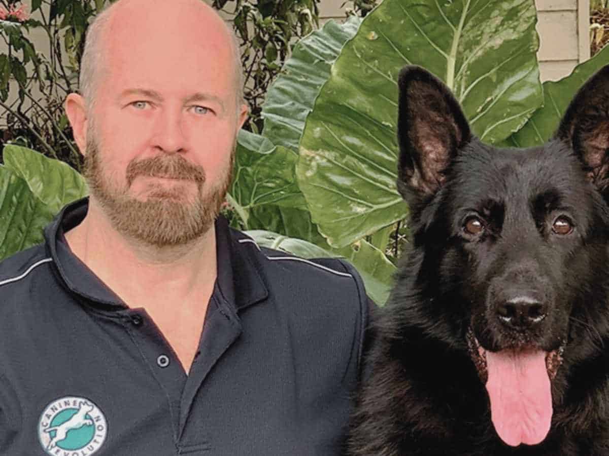 Trainer Glenn Cooke profile photo with black dog. He writes for Animal Friendly Life about dog training tips